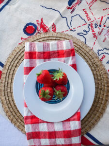 Summer table setting with white plates and strawberries on top